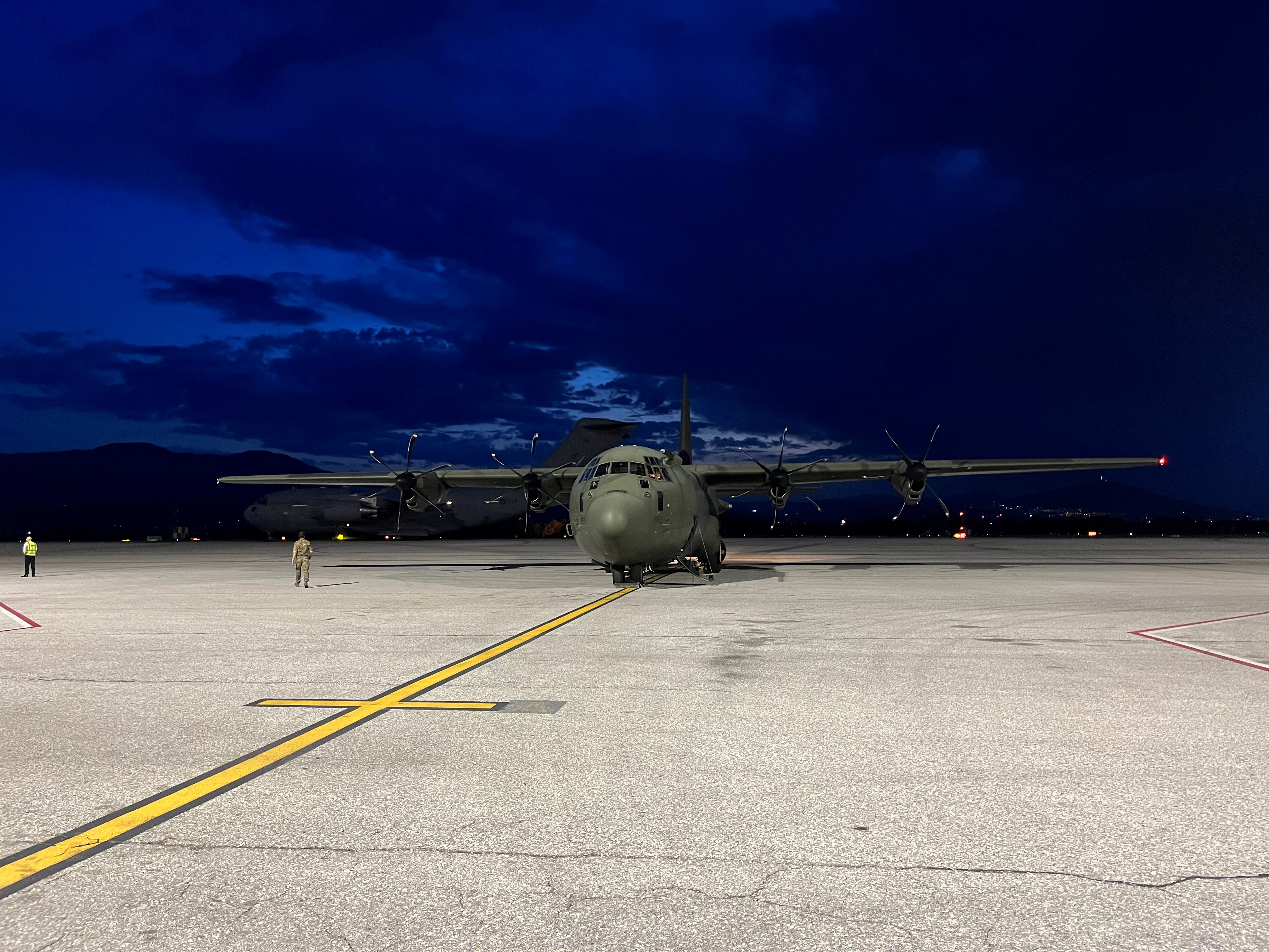 RAF Hercules on airfield at night.